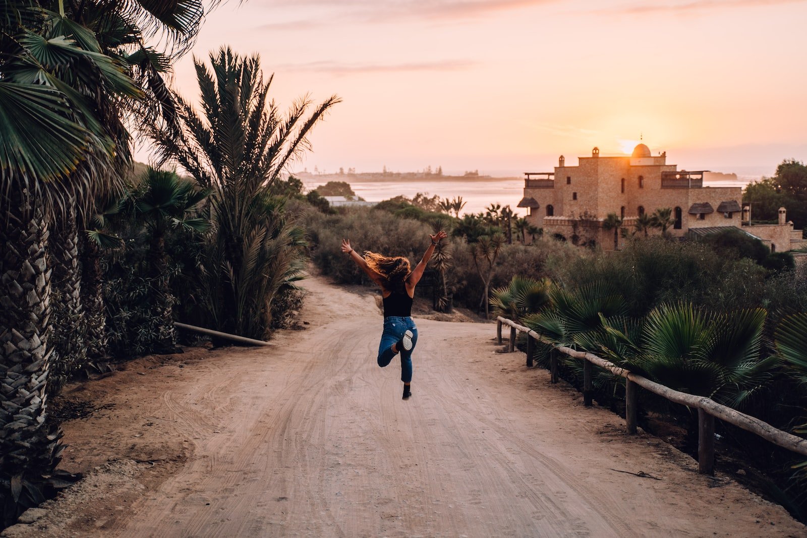 a person jumping in the air on a dirt road