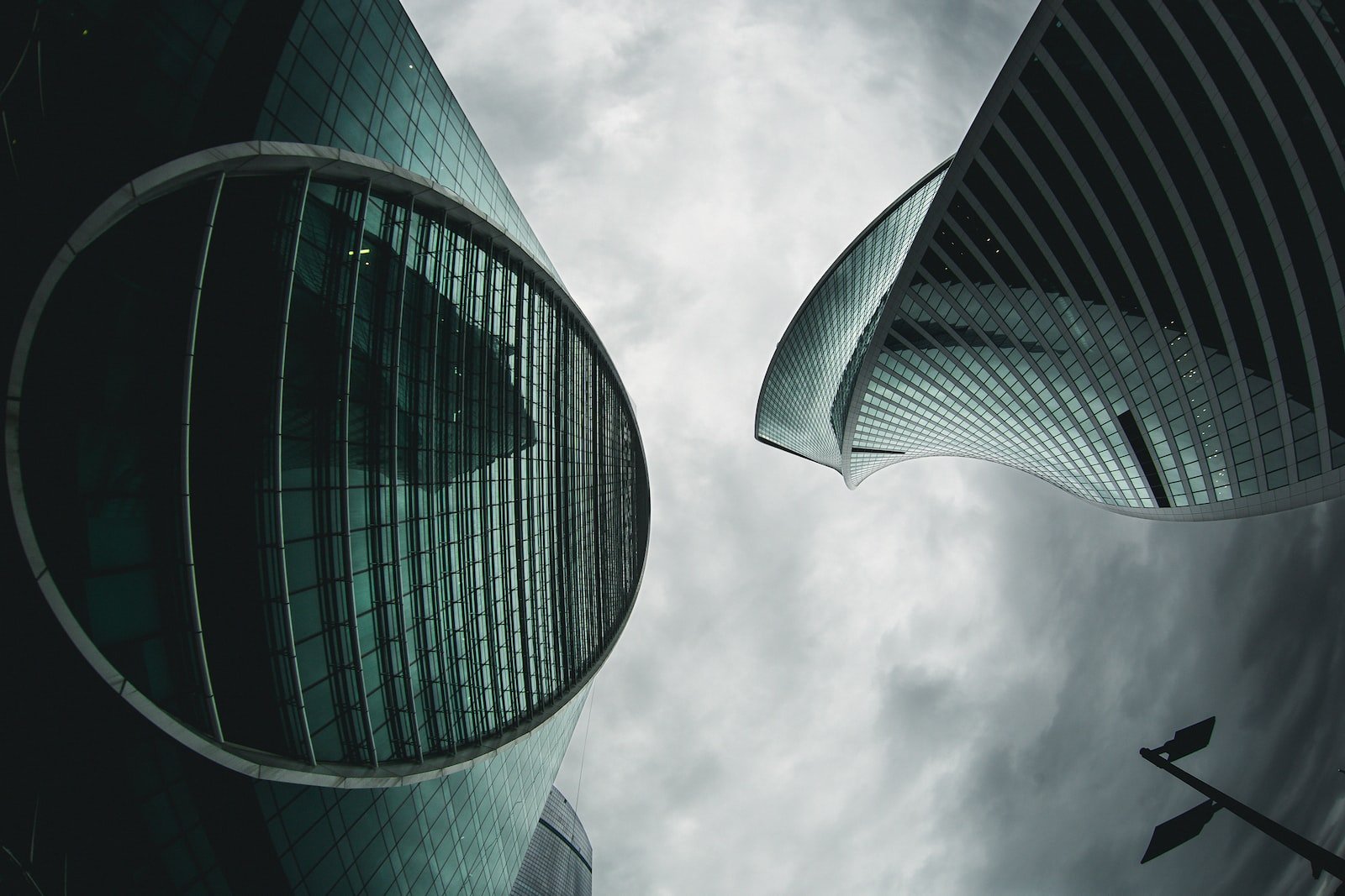 architectural photography of green high-rise buildings under white and gray sky